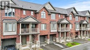 Hamilton townhouse for rent - A row of red brick houses with balconies and garages.