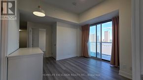 Toronto (Don Valley Village) condo for rent - A room with a sliding glass door leading to a balcony with a view of the city.
