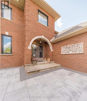 Vaughan (East Woodbridge) apartment for rent - A brick house with a stone sculpture on the wall.