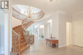 Vaughan (East Woodbridge) apartment for rent - A large open space with a spiral staircase and a table with a vase of flowers on it.