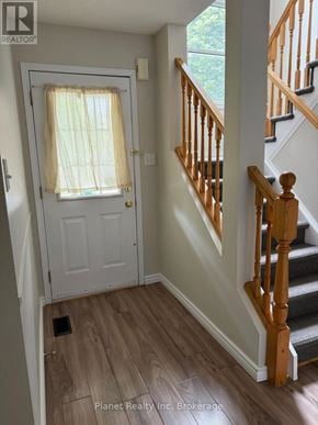 Guelph (Downtown) townhouse for rent - A hallway with a staircase and a door with a window.