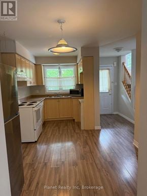 Guelph (Downtown) townhouse for rent - A kitchen with wooden floors and a refrigerator.