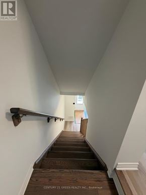 Kitchener townhouse for rent - A long hallway with wooden stairs and white walls.