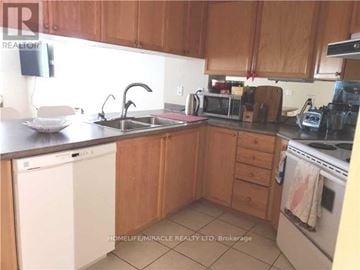 Toronto (Bay Street Corridor) condo for rent - A kitchen with wooden cabinets and a white dishwasher.