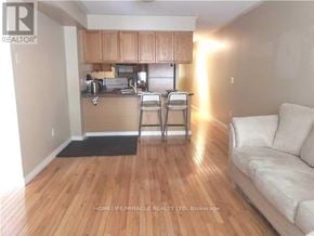 Toronto (Bay Street Corridor) condo for rent - A living room with a couch, a chair, and a kitchen area with a sink and cabinets.
