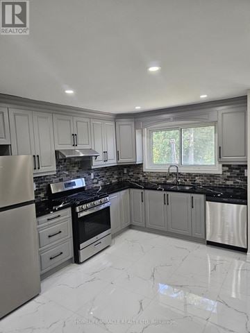 Brampton (Southgate) apartment for rent - A modern kitchen with a black countertop and stainless steel appliances.