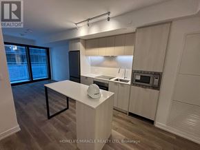 Hamilton (Beasley) condo for rent - A modern kitchen with a white countertop and a black stove.