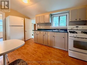 Niagara Falls (Downtown) apartment for rent - A kitchen with a white refrigerator, white cabinets, and a white stove.