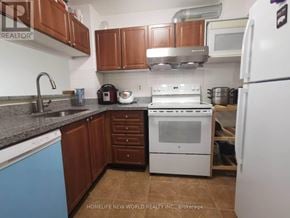 Toronto (Morningside) condo for rent - A kitchen with a white refrigerator, white stove, and brown cabinets.