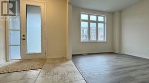 Whitby townhouse for rent - A room with a door and a window with a view of a building outside.
