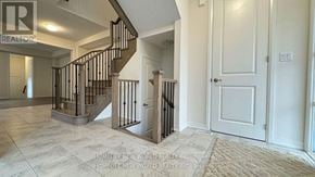 Whitby townhouse for rent - A spacious foyer with a staircase and a closed door.