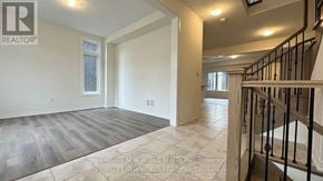 Whitby townhouse for rent - A spacious room with a staircase on the right side.