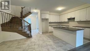Whitby townhouse for rent - A spacious kitchen and living room with a staircase.