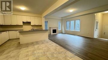 Whitby townhouse for rent - A spacious kitchen with white cabinets and a large island.