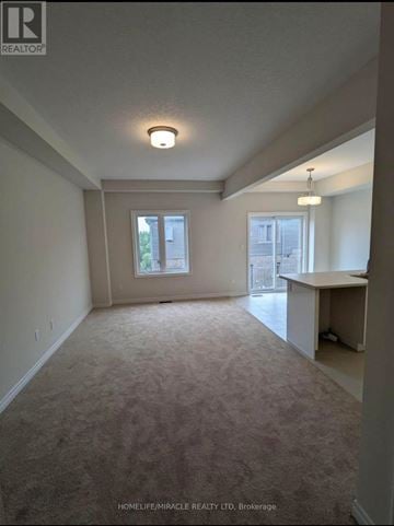 Brantford townhouse for rent - A spacious room with a carpeted floor and a window.