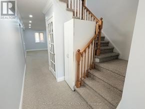 Whitby (Pringle Creek) townhouse for rent - A staircase with a wooden banister and beige carpeted steps.