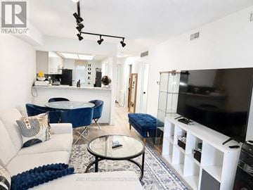 Mississauga (Hurontario) condo for rent - A living room with a white couch and a blue chair.
