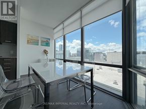 Toronto (Bay Street Corridor) condo for rent - A room with a glass table and chairs with a view of the city outside the window.