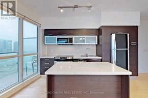 Toronto (Bay Street Corridor) condo for rent - A modern kitchen with a large island in the middle.