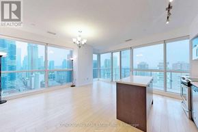 Toronto (Bay Street Corridor) condo for rent - A large, empty room with a city view through the windows.