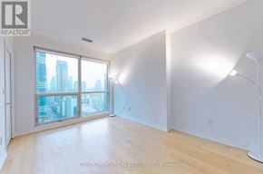 Toronto (Bay Street Corridor) condo for rent - A spacious room with a large window overlooking a cityscape.
