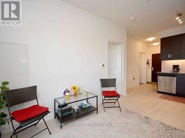 Mississauga (Hurontario) condo for rent - A living room with a red chair and a glass coffee table.