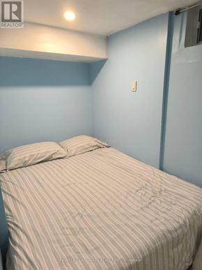 Richmond Hill (Crosby) apartment for rent - A bed with a striped comforter is in a room with blue walls.