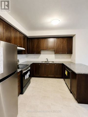Brantford townhouse for rent - A kitchen with brown cabinets and a granite counter top.