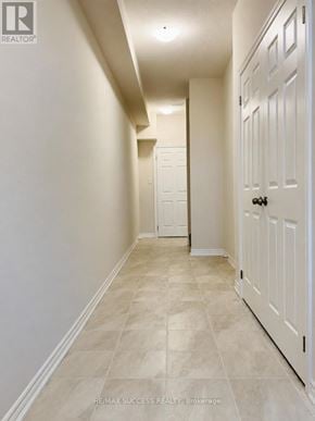 Brantford townhouse for rent - A hallway with a white door and tiled floor.