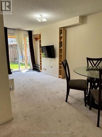 Toronto (Centennial Scarborough) apartment for rent - A living room with a carpeted floor and a glass table with chairs.