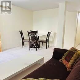 Toronto (Centennial Scarborough) apartment for rent - A living room with a couch, chairs and a dining table.
