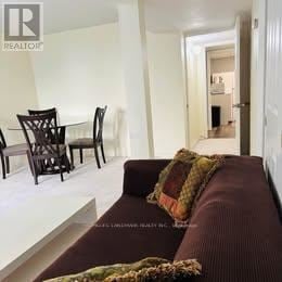 Toronto (Centennial Scarborough) apartment for rent - A living room with a brown couch and a glass table.