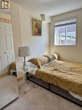 Toronto (Centennial Scarborough) apartment for rent - A bedroom with a bed, lamp, and painting on the wall.