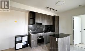 Toronto (Annex) condo for rent - A modern kitchen with a black countertop and a built-in oven.