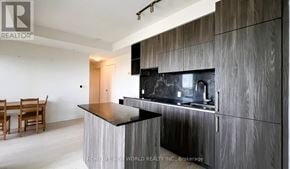 Toronto (Annex) condo for rent - A modern kitchen with a wooden island and a black countertop.