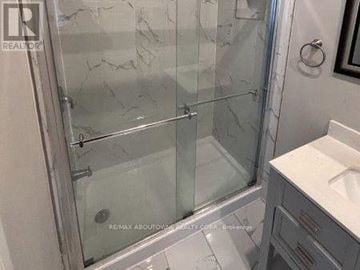 Hamilton (Stinson) fourplex for rent - A bathroom with a glass shower door and a white sink.
