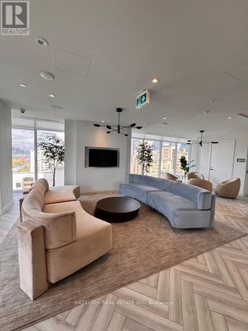 Toronto (Kensington-Chinatown) condo for rent - A living room with a grey couch and a brown rug.