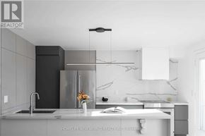 Markham (Cornell) townhouse for rent - A modern kitchen with a sink, refrigerator, and a hanging light fixture.
