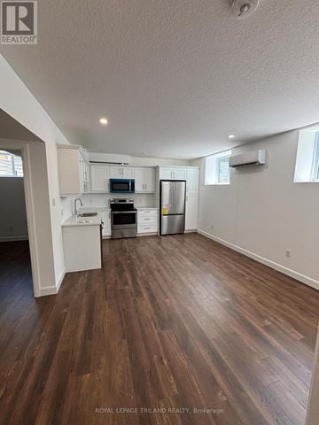 London East (East I) duplex for rent - A kitchen with white cabinets and a wooden floor.