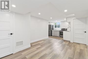 London South (South E) apartment for rent - A spacious kitchen with white cabinets and a wooden floor.