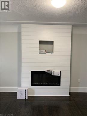 Hamilton apartment for rent - A white fireplace with a black screen and a white box on the floor.