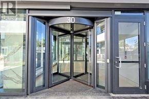 Toronto (Mimico) condo for rent - The entrance to a building with glass doors and a sign that reads "30".