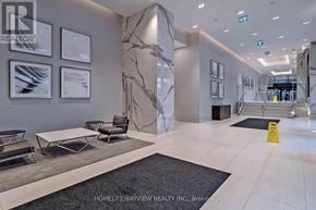 Toronto (Mimico) condo for rent - A reception area with a marble pillar and framed pictures on the wall.