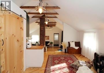 St. Catharines (Downtown) multi-family for rent - A living room with a red rug and a wooden door.