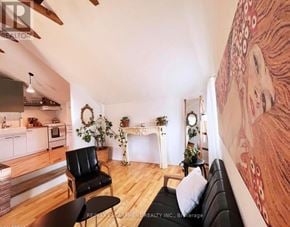 St. Catharines (Downtown) multi-family for rent - A living room with a fireplace and a painting on the wall.