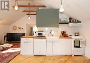 St. Catharines (Downtown) multi-family for rent - A kitchen with white cabinets and a wooden floor.