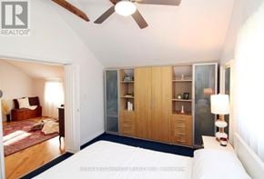 St. Catharines (Downtown) multi-family for rent - A bedroom with a bed, a ceiling fan, and a wardrobe.