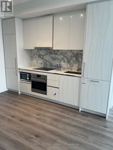 Vaughan (Vaughan Corporate Centre) condo for rent - A modern kitchen with white cabinets and a marble backsplash.