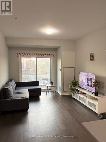Oakville (Go Glenorchy) condo for rent - A living room with a grey couch and a television on a white stand.