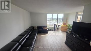 Toronto (Brookhaven-Amesbury) condo for rent - A living room with a long black couch and a flat screen TV.